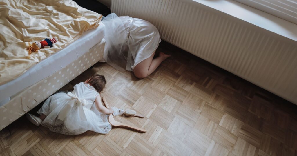 Braut und Kind suchen etwas unter dem Bett. Fehler bei Hochzeitsplanung